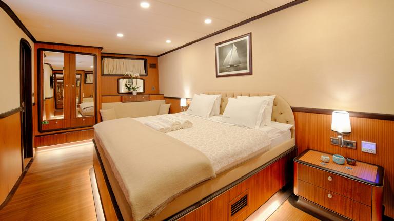 The decor and furniture elements in the spacious bedroom are well chosen. You can see a picture and a flower in a pot